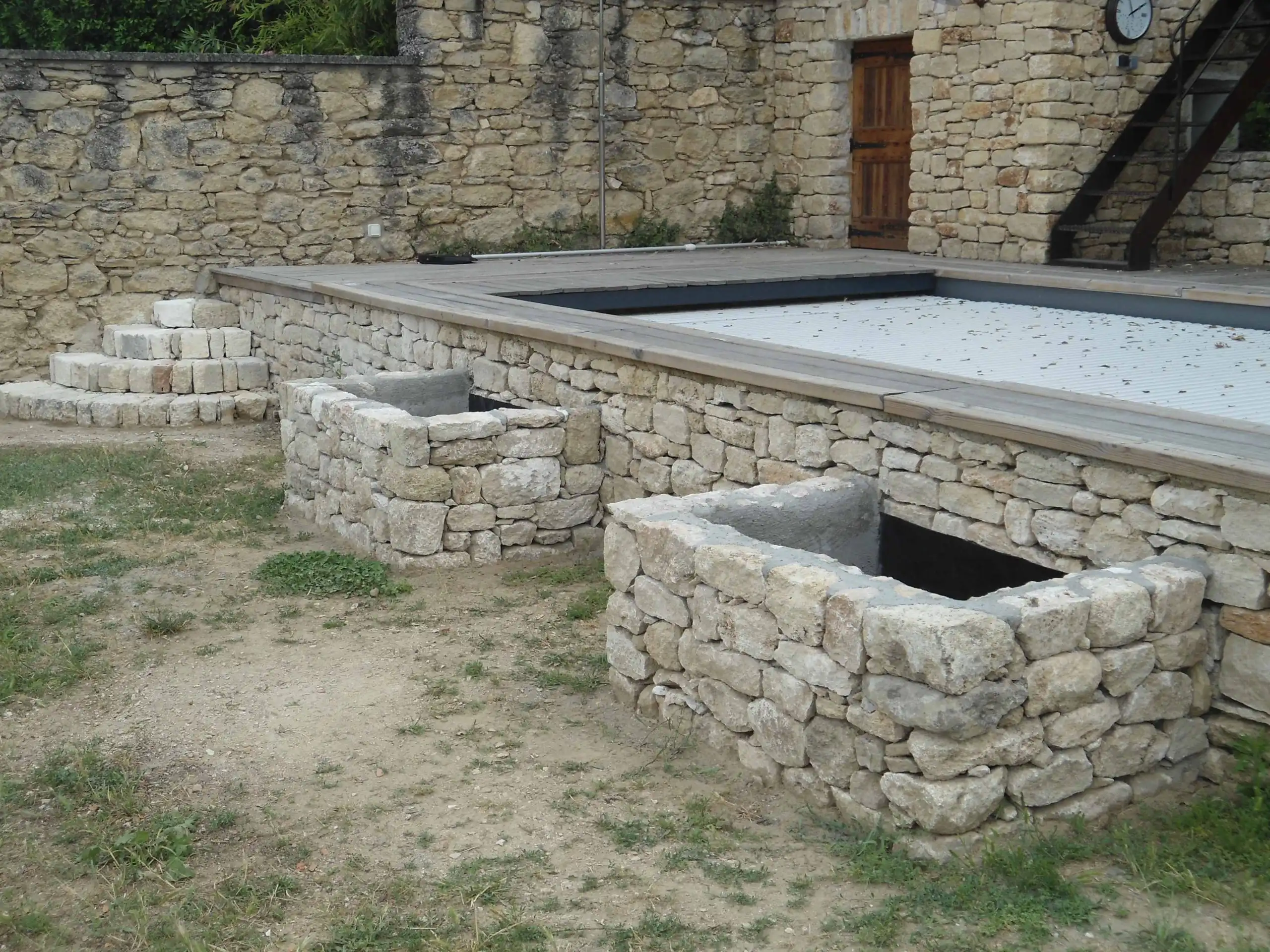 Aménagement extérieur en pierre naturelle avec murets et marches réalisé dans le Luberon.