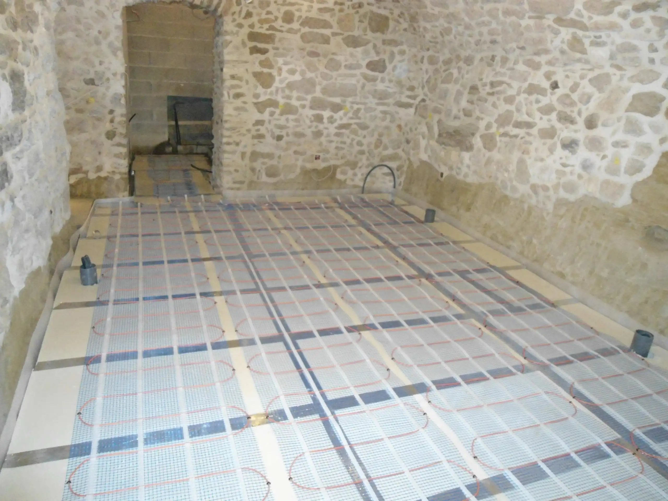 Installation d’un chauffage au sol dans une cave en pierre lors d’une rénovation