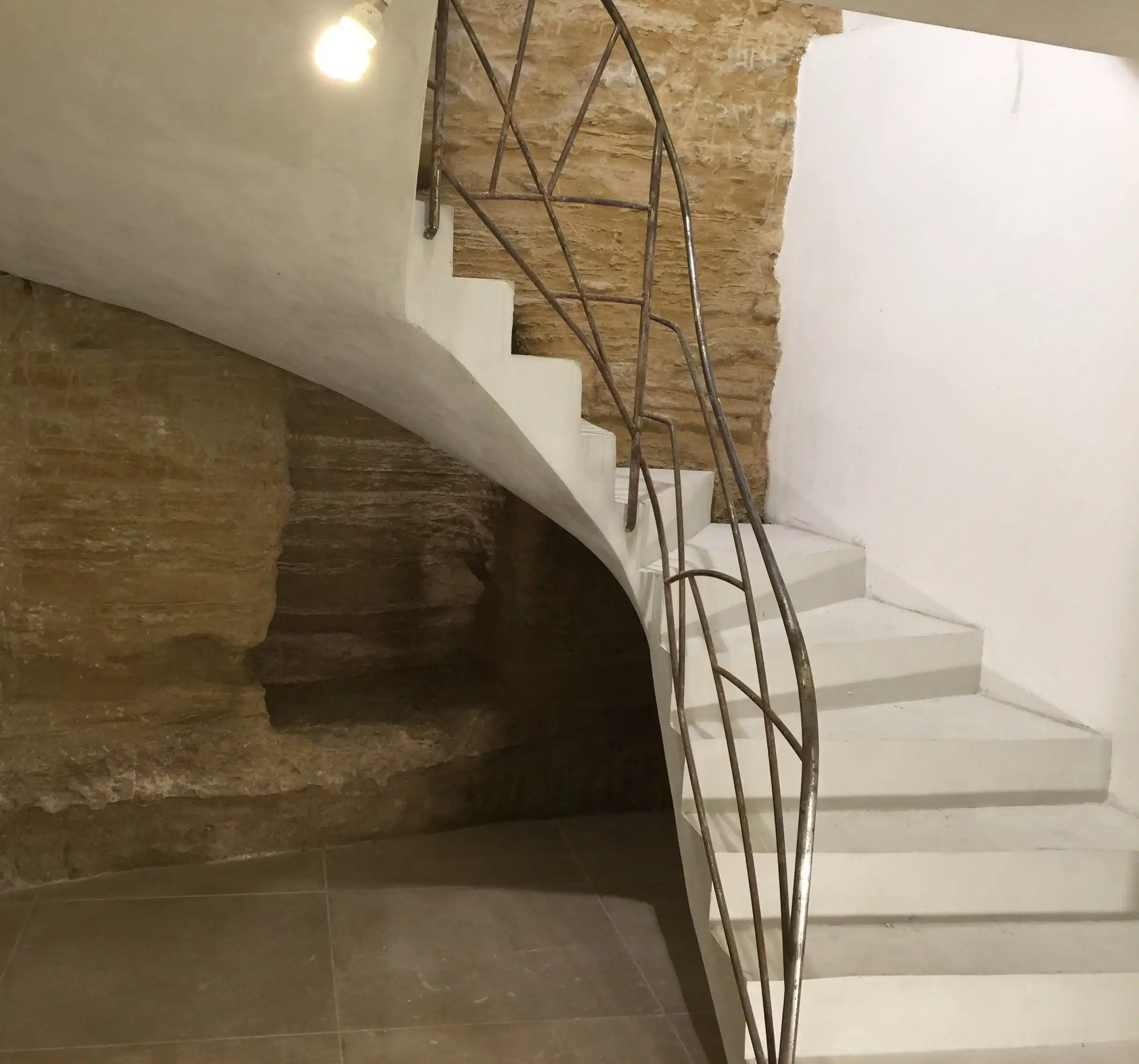 Escalier maçonné sur mesure avec garde-corps métallique dans une rénovation de bâtisse ancienne