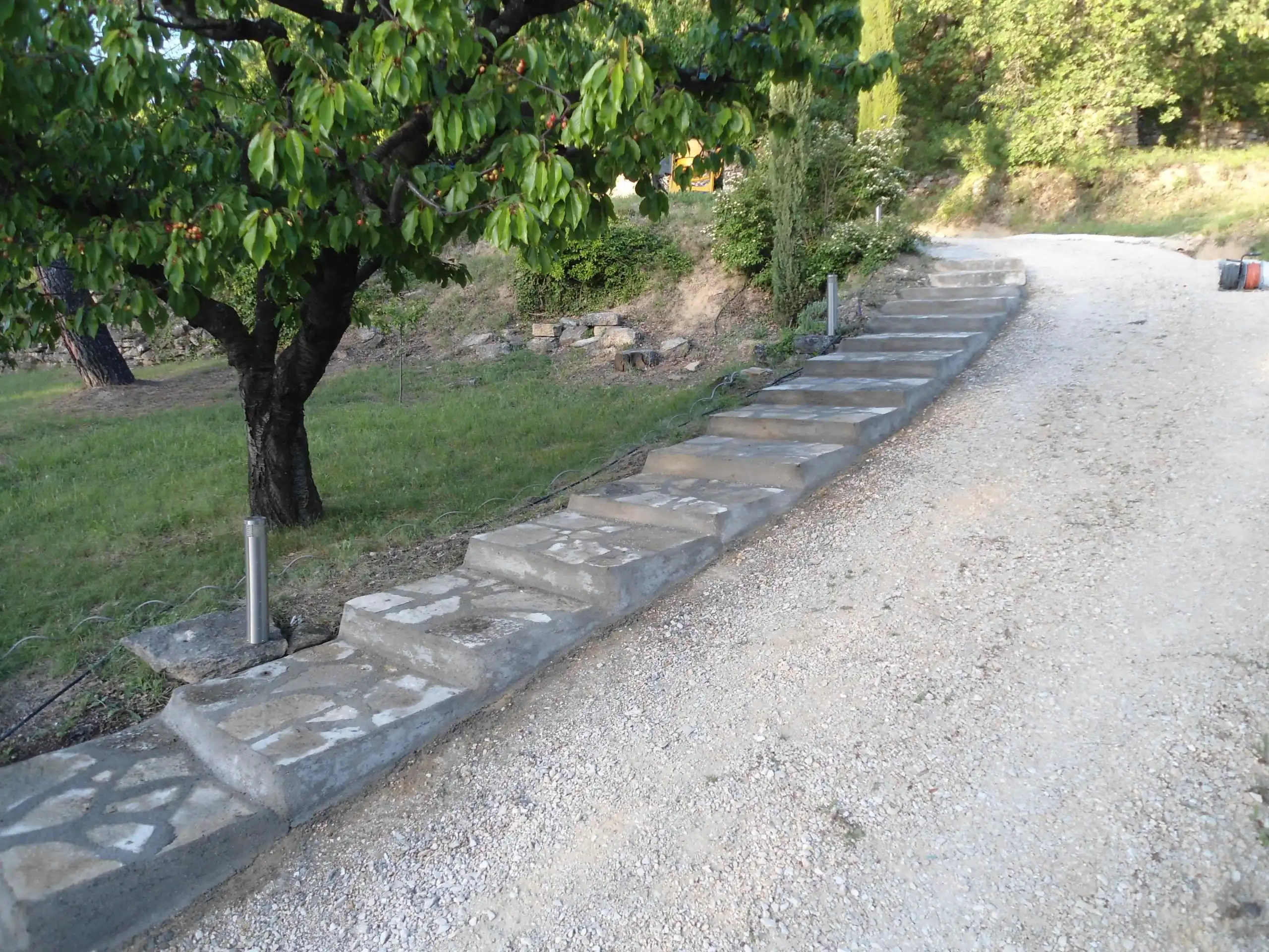 Escalier extérieur en pierre naturelle aménagé dans un jardin en pente dans le Luberon.
