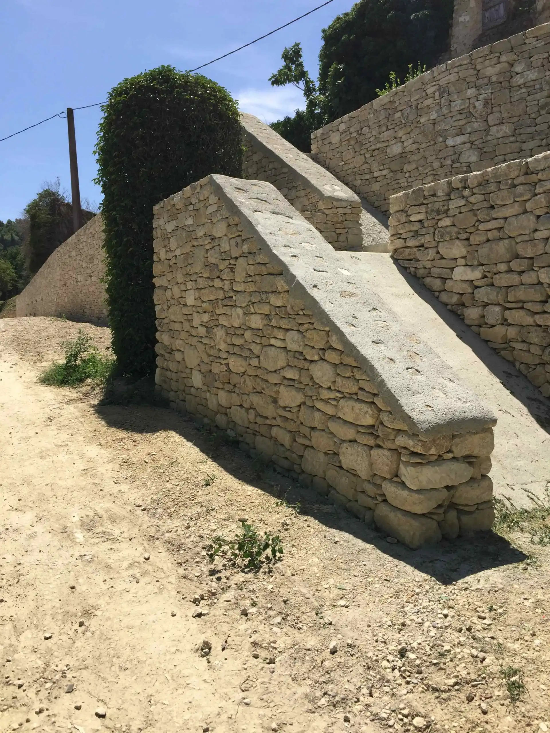 Escalier intégré à des restanques en pierre sèche réalisé sur un terrain en pente dans le Luberon.