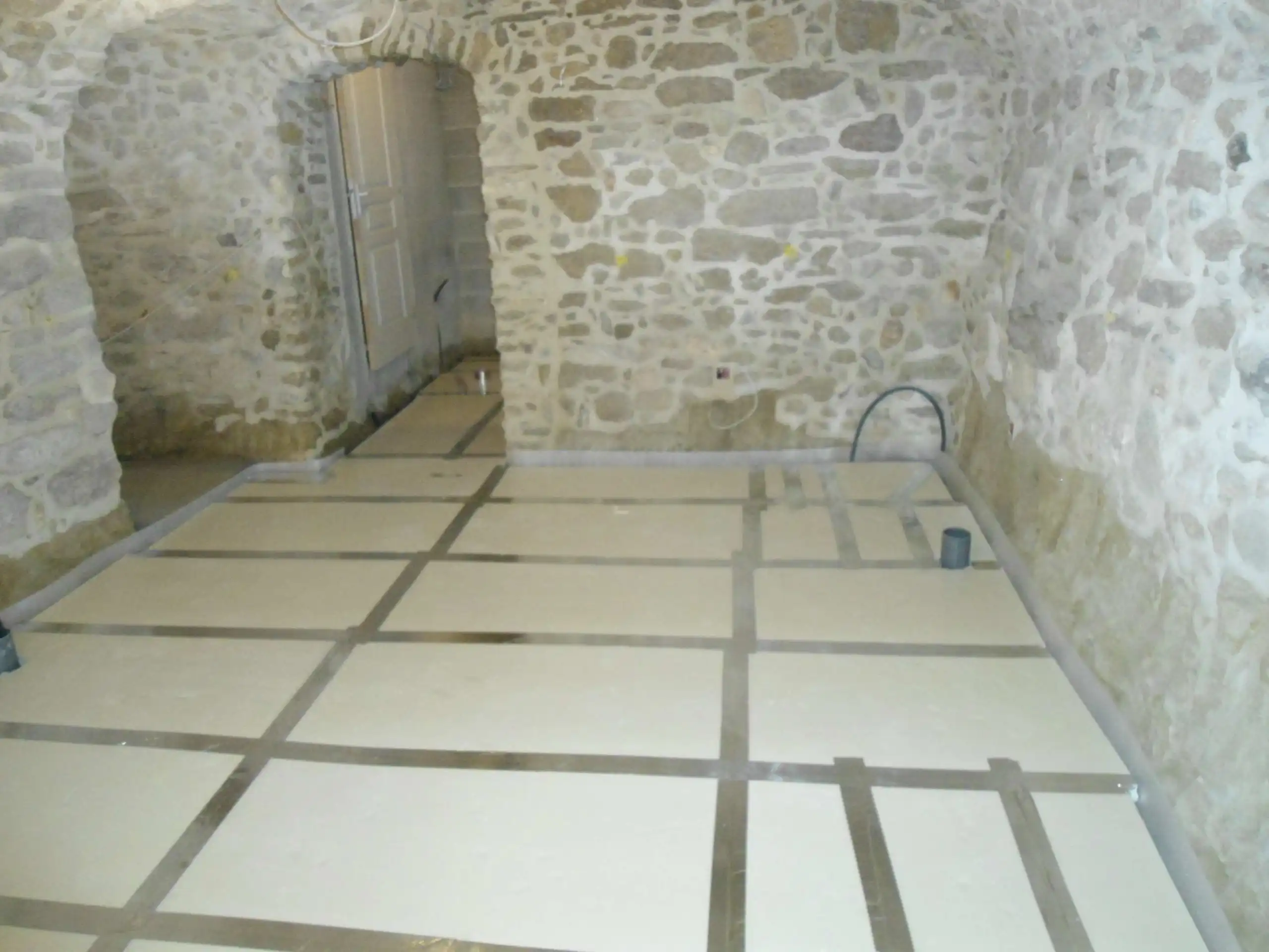 Isolation du sol d’une cave en pierre avant réalisation de la chape dans une maison ancienne