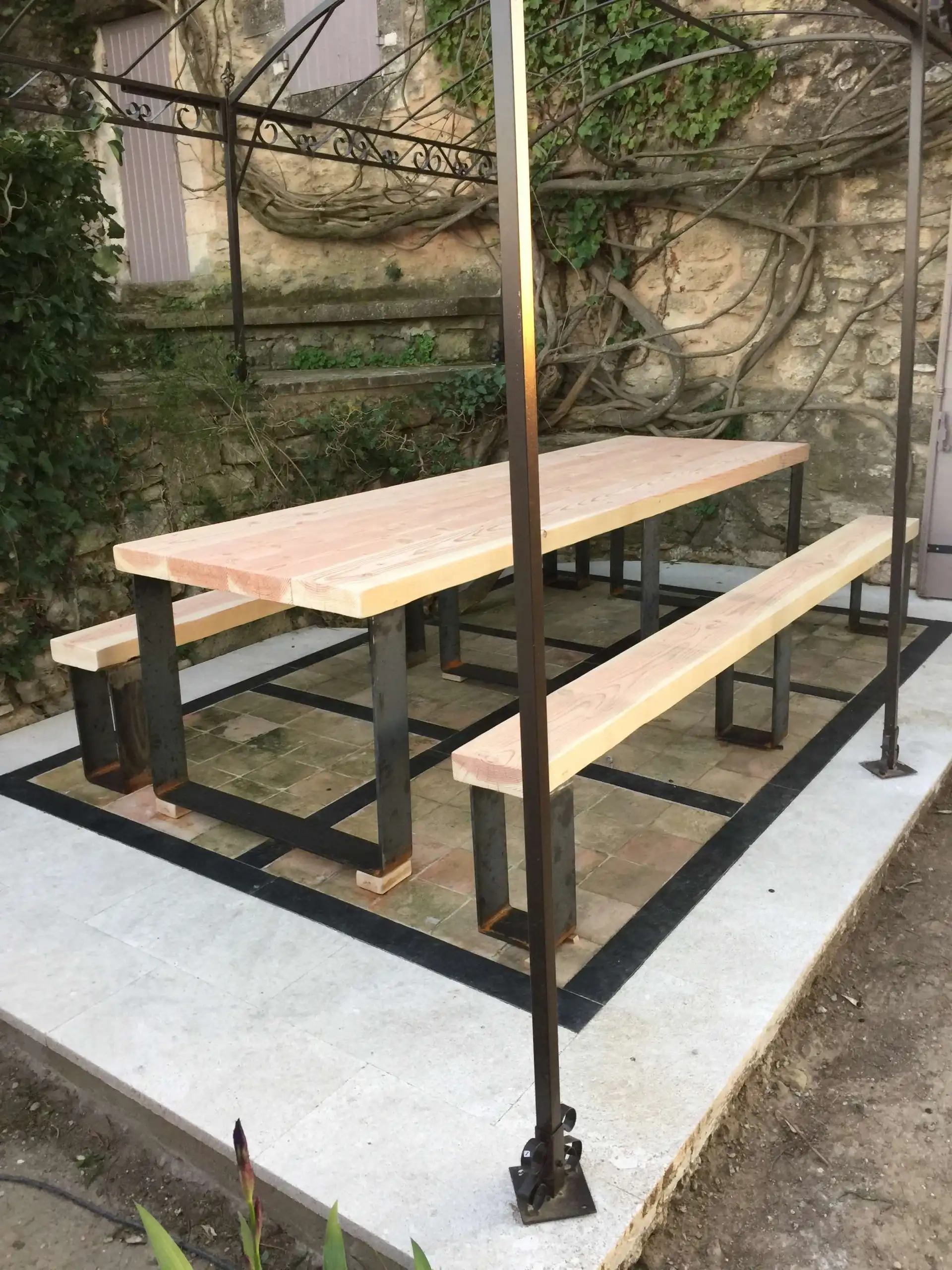 Table et bancs sur mesure en bois et métal installés sur une terrasse rénovée