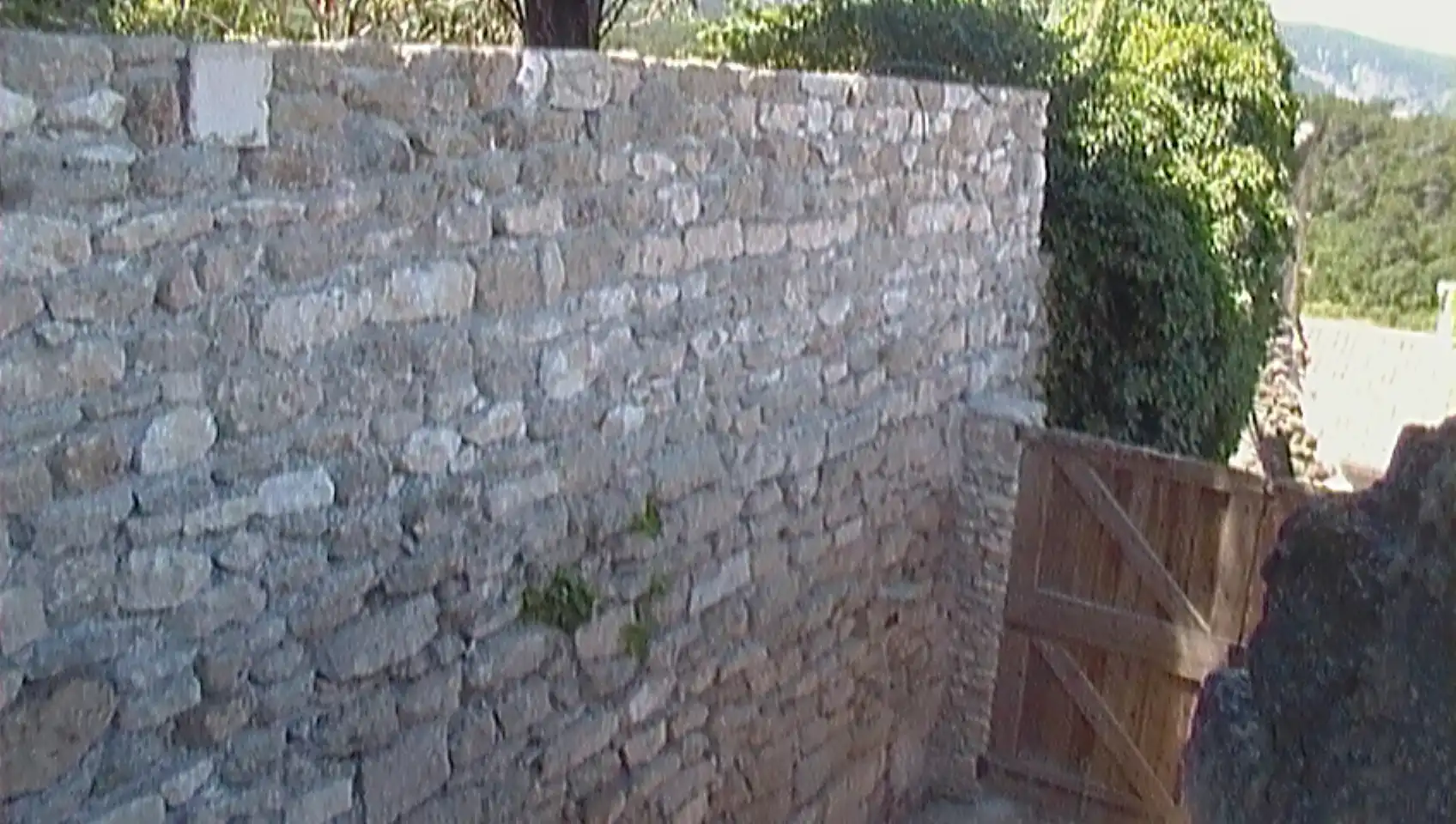 Mur en pierre sèche réalisé artisanalement pour délimiter une propriété dans le Luberon.