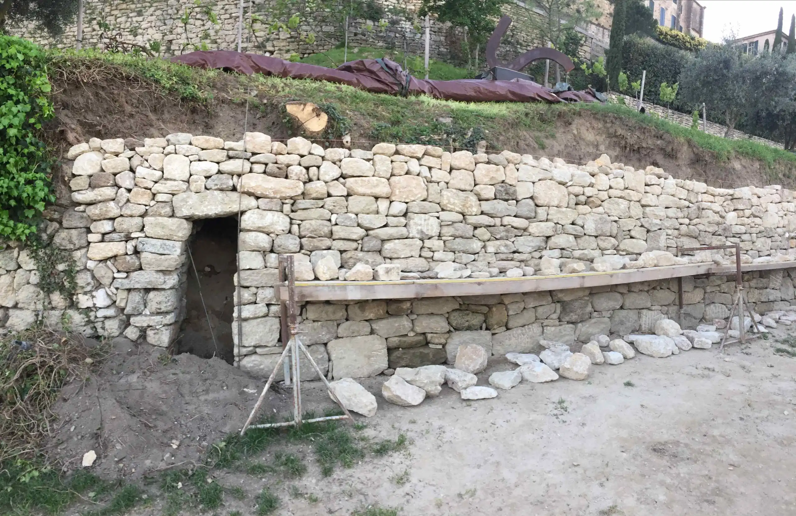 Mur de soutènement en pierre naturelle avec passage intégré réalisé dans le Luberon.