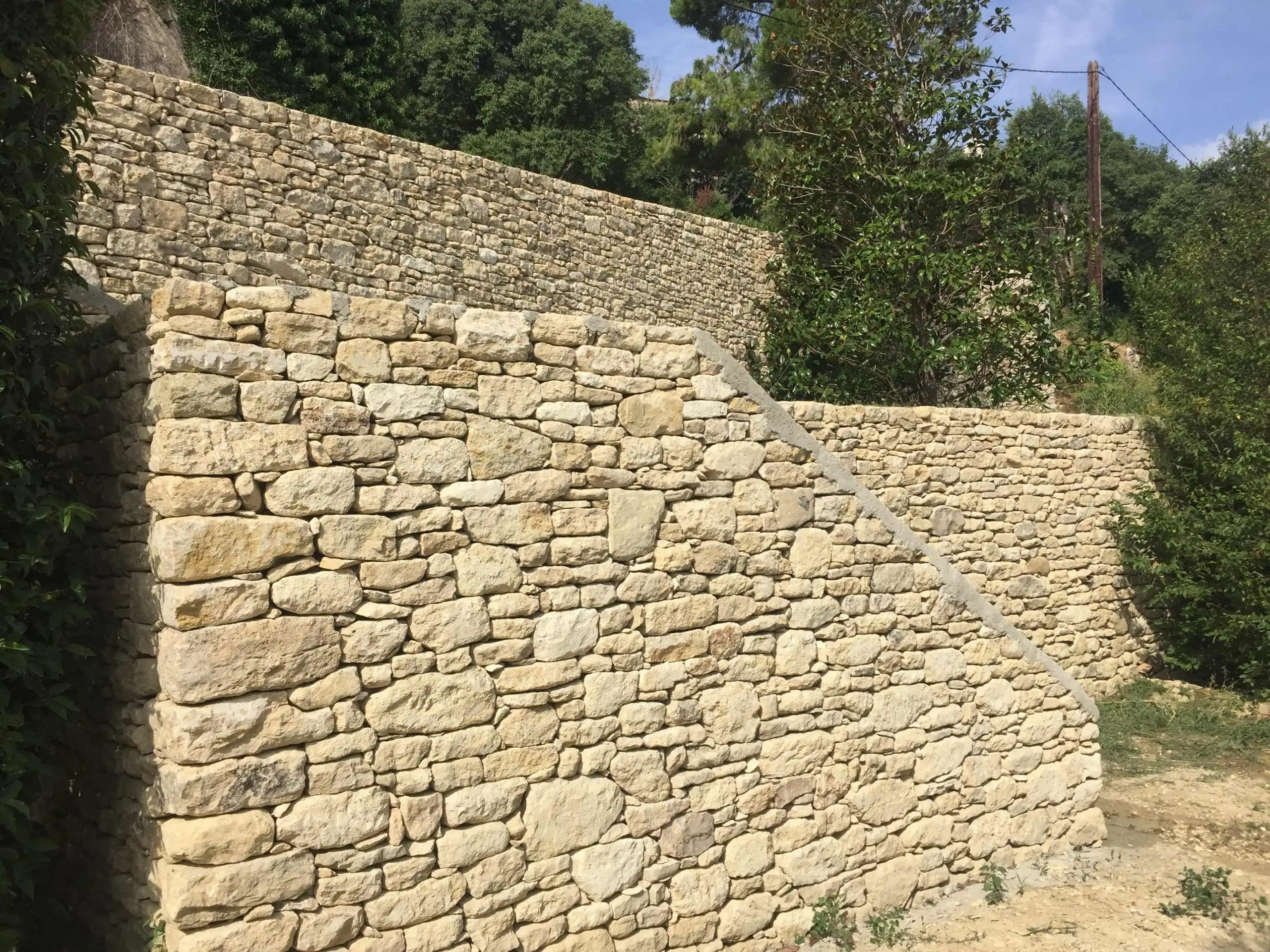 Mur de soutènement et restanques en pierre naturelle réalisés sur un terrain en pente dans le Luberon.