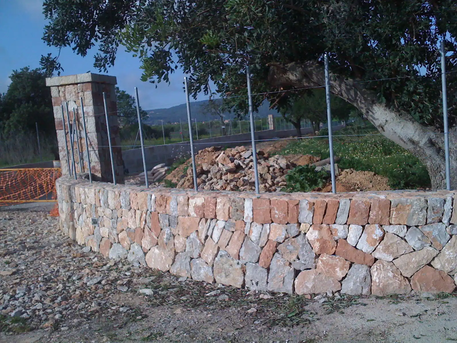 Muret en pierre naturelle avec pilier d'entrée réalisé par un artisan maçon à Ménerbes dans le Luberon.