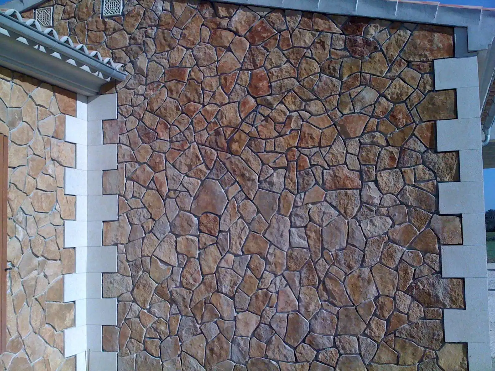 Habillage de façade en pierre naturelle réalisé sur une maison dans le Luberon par un artisan spécialisé en pierre.