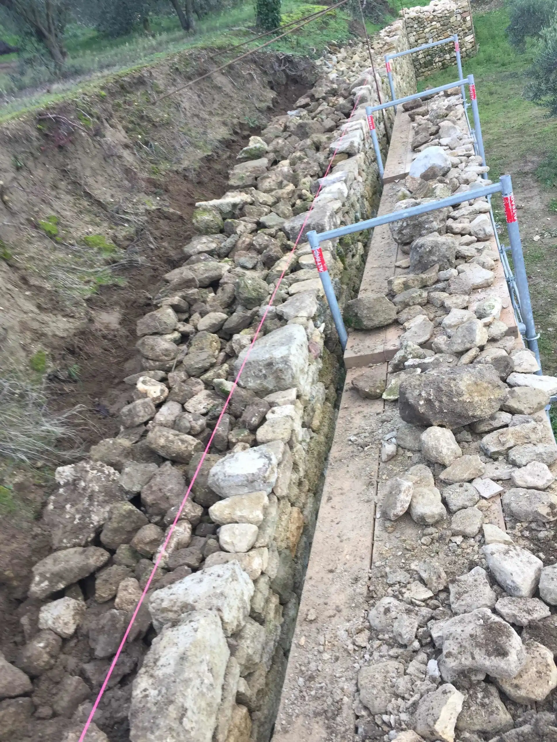 Reconstruction d’un mur de soutènement en pierre naturelle avec mise en œuvre de blocs massifs et drainage arrière.