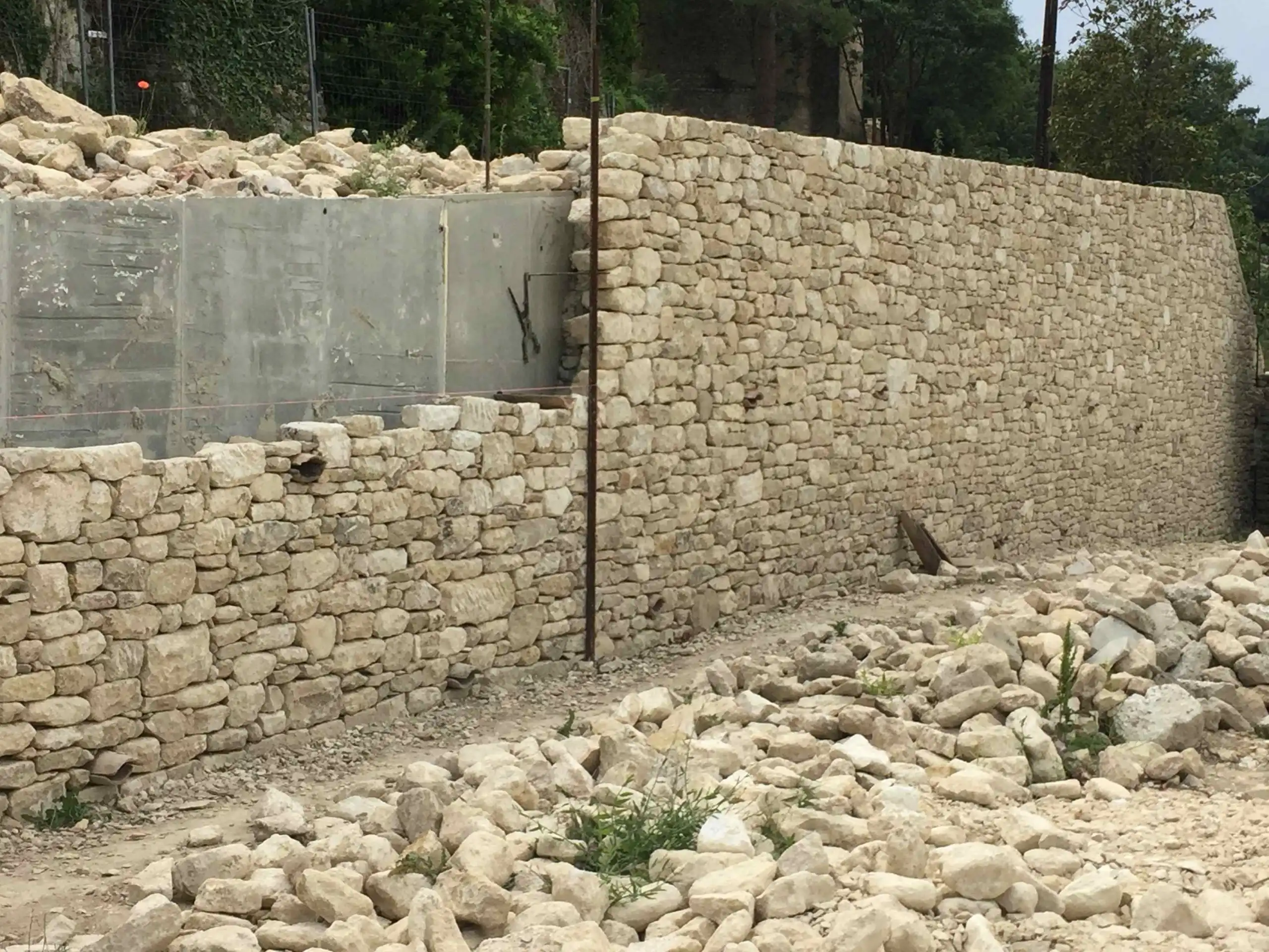 Mur de soutènement en pierre sèche réalisé sur un terrain en pente dans le Luberon.