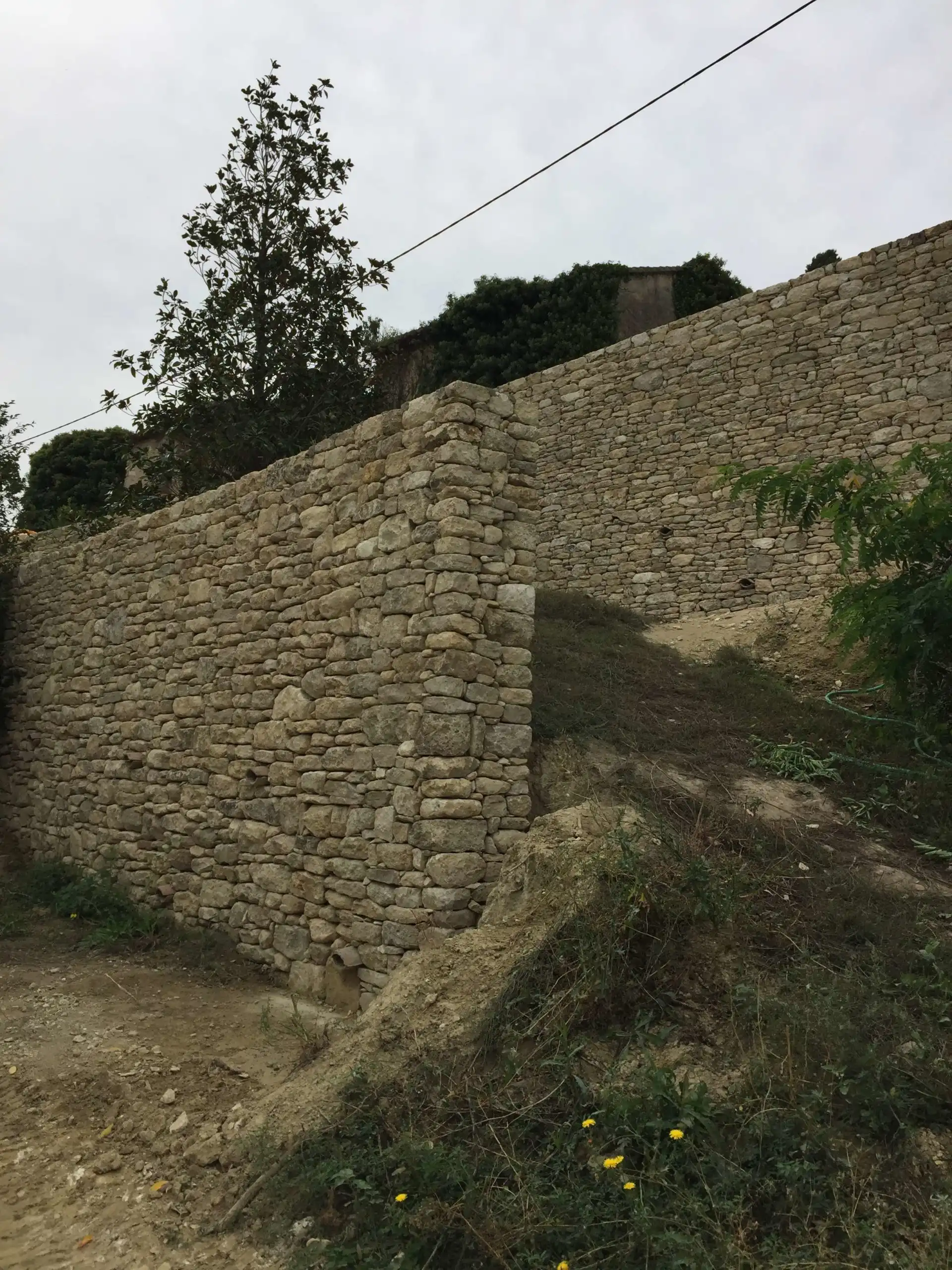 Ensemble de restanques en pierre sèche réalisées sur un terrain en pente dans le Luberon.
