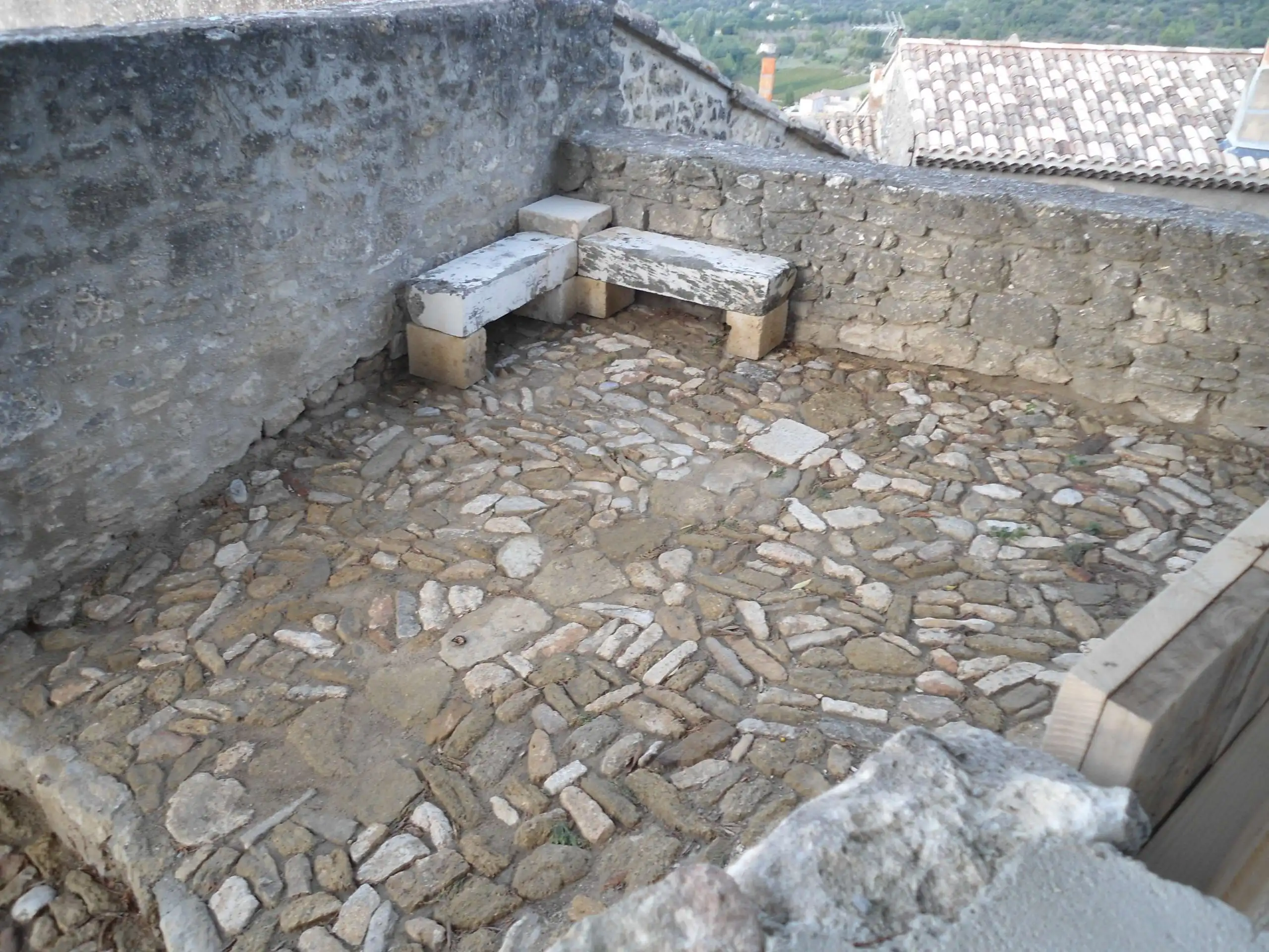 Terrasse en calade avec banc en pierre naturelle réalisée dans un village du Luberon.