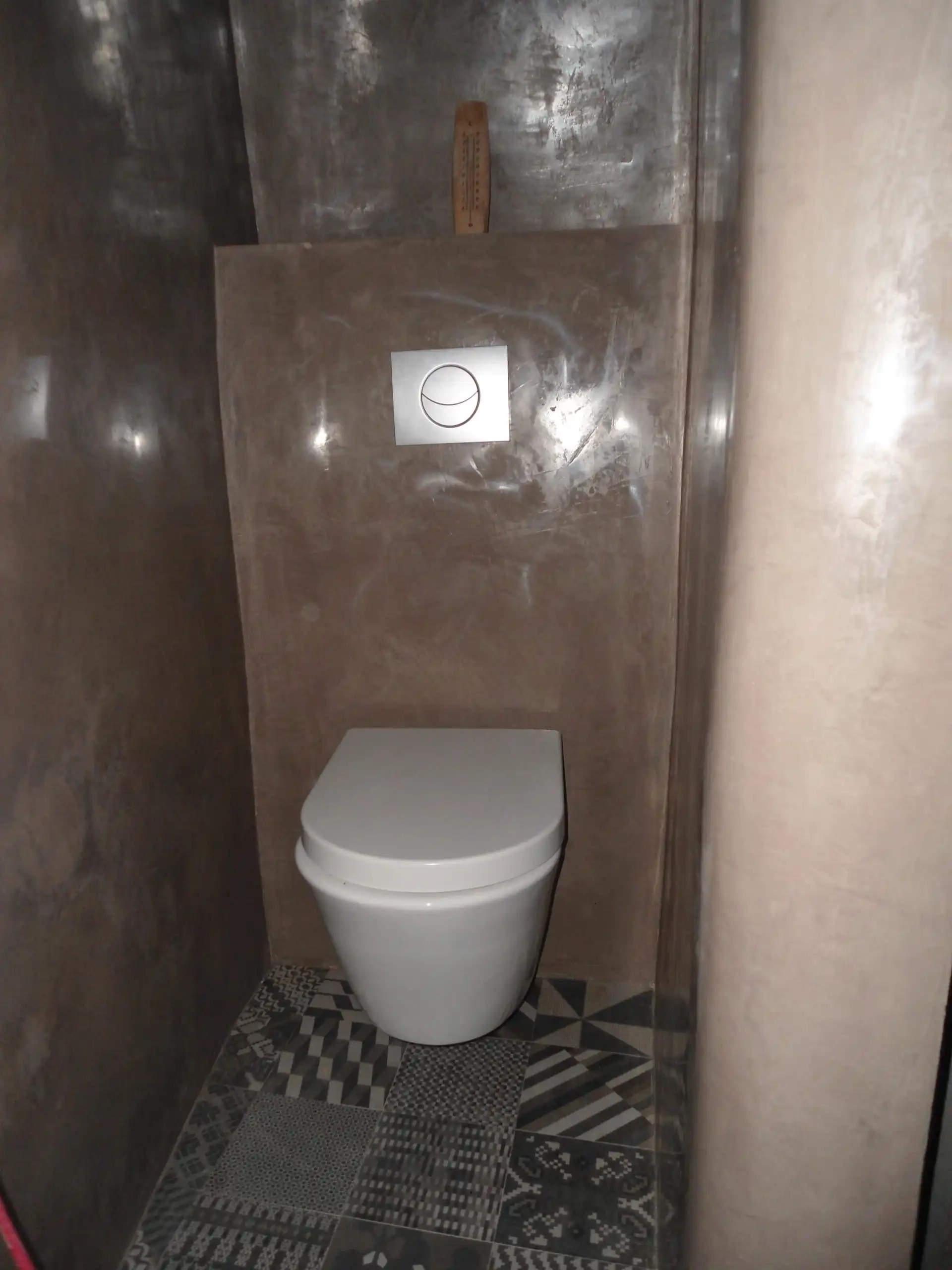 WC suspendu avec habillage en béton ciré dans une maison ancienne rénovée